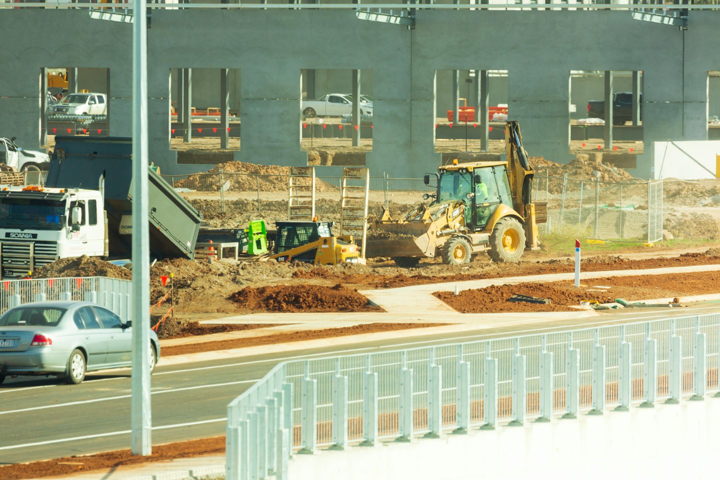 Baustelle mit schweren Maschinen und einem Neubau.
